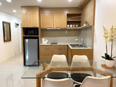 a kitchen with a glass table and white chairs at Patong Tower apartment by Lofty in Patong Beach