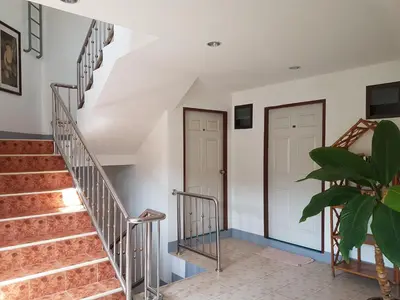 a staircase in a house with two doors and a plant at Deng's kamala beach Guesthouse in Kamala Beach