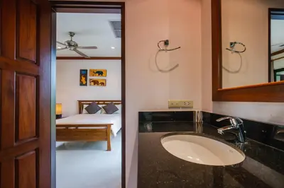 a bathroom with a sink and a bedroom with a bed at Lotus Pool Villa Your Own Slice Of Island Paradise in Rawai Beach