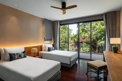 a hotel room with two beds and a window at Noku Phuket in Chalong