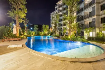 a large swimming pool in front of a building at night at Title НайЯнг NaiYang in Nai Yang Beach