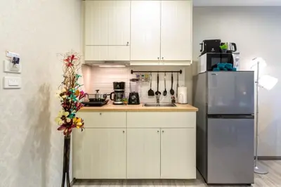 a kitchen with white cabinets and a refrigerator at Title НайЯнг NaiYang in Nai Yang Beach