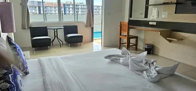 a bedroom with a bed with pillows on it at AM Surin Place in Surin Beach