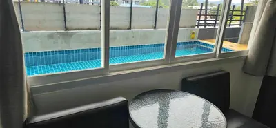 a view of a swimming pool through a window at AM Surin Place in Surin Beach