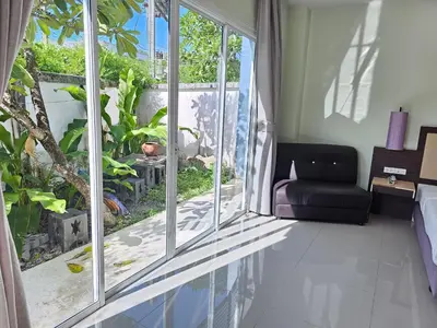 a living room with a large window and a couch at AM Surin Place in Surin Beach