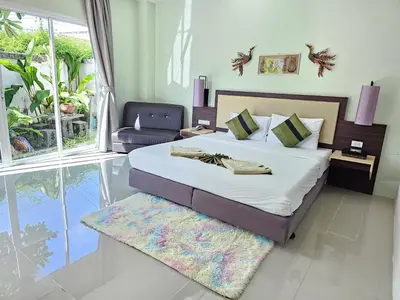 a bedroom with a bed and a chair in it at AM Surin Place in Surin Beach