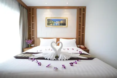 a bed with two swans made out of flowers at The Patong Center Hotel in Patong Beach