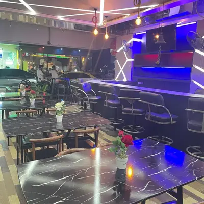 a restaurant with tables and chairs and a bar at The Patong Center Hotel in Patong Beach
