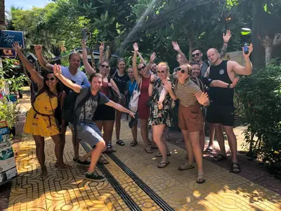 a group of people posing for a picture with their hands in the air at Sweed Dee Hostel in Phi Phi Don