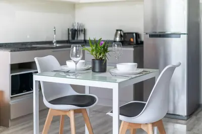 a kitchen with a table and chairs with wine glasses at Tropical Living Surin Beach Phuket in Surin Beach