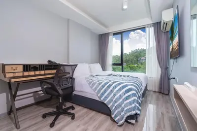 a bedroom with a desk and a bed and a desk and a chair at Tropical Living Surin Beach Phuket in Surin Beach