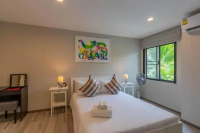 a bedroom with a large white bed and a desk at Title Naiyang residence Excellent location with pool view in Nai Yang Beach