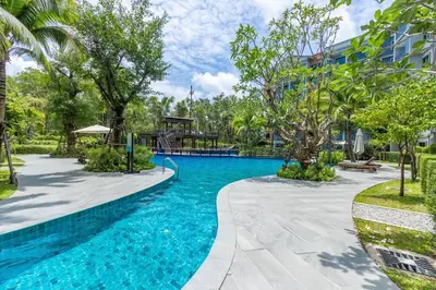 a pool at a resort with trees and a building at Title Naiyang residence Excellent location with pool view in Nai Yang Beach