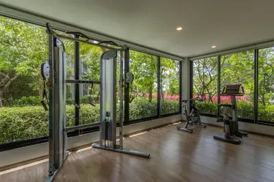 a gym with treadmills and ellipticals in a room with windows at Title Naiyang residence Excellent location with pool view in Nai Yang Beach
