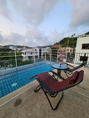 a balcony with a table and a swimming pool at La Xenia Hotel Kata Beach in Kata Beach