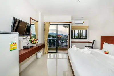 a hotel room with two beds and a television at The Topaz Residence Phuket Town in Phuket Town