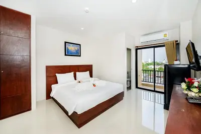 a bedroom with a bed and a balcony at The Topaz Residence Phuket Town in Phuket Town