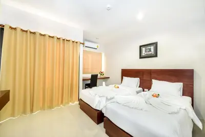 a bedroom with two beds with white sheets at The Topaz Residence Phuket Town in Phuket Town