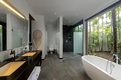 a bathroom with a tub and a large window at Stunning 5BR villa with freshwater pool & tropical garden in Ban Phru Champa