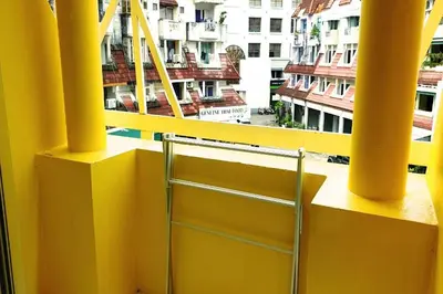 a yellow balcony with a view of a building at Beehive Phuket Old Town Hostel in Phuket Town