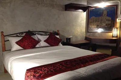 a bedroom with a large white bed with red pillows at Beehive Phuket Old Town Hostel in Phuket Town