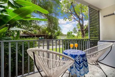 a balcony with a table and two glasses on it at Nayang Beach Brand New Executive Luxury Condo in Nai Yang Beach