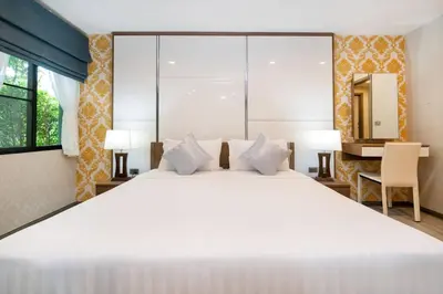 a bedroom with a large white bed and a desk at Nayang Beach Brand New Executive Luxury Condo in Nai Yang Beach