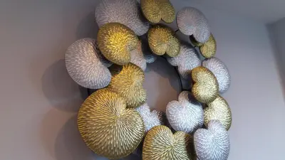 a wreath of different colored shells on a wall at Green House Phuket in Ban Pa Khlok