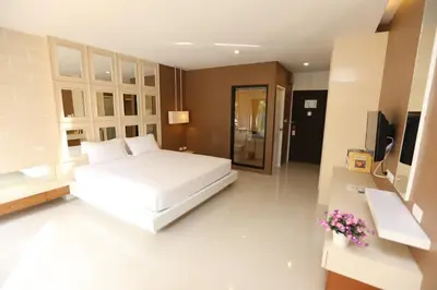 a bedroom with a white bed and a television at Naka Residence in Phuket Town