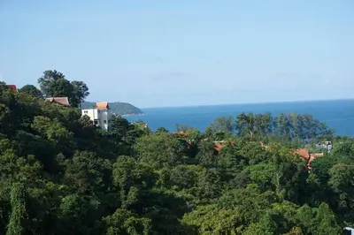 a house on a hill with the ocean in the background at Phuket Kamala, Spectacular Seaviews, Private pool, 3 BR in Kamala Beach