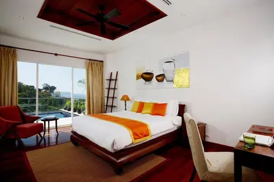 a bedroom with a bed and a desk and a window at Phuket Kamala, Spectacular Seaviews, Private pool, 3 BR in Kamala Beach