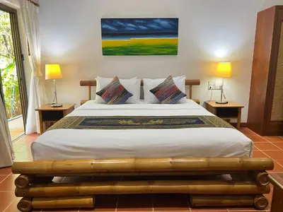 a bedroom with a large bed with two lamps at Luxury Four Bed Villa Jasmine, infinity pool, full staff , chef and breakfasts in Kata Beach