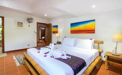 two beds in a hotel room with white sheets at Luxury Four Bed Villa Jasmine, infinity pool, full staff , chef and breakfasts in Kata Beach