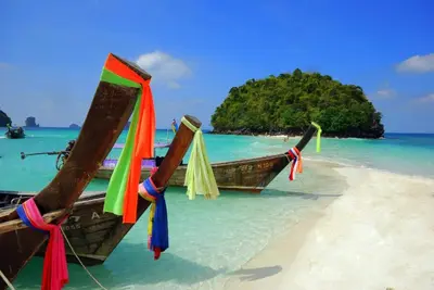 a boat on the shore of a beach at Luxury Four Bed Villa Jasmine, infinity pool, full staff , chef and breakfasts in Kata Beach