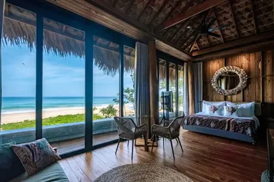 a bedroom with a bed and a view of the ocean at Sealord Naithon Beachfront Villa in Nai Thon Beach