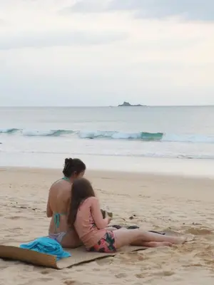 two women sitting on a towel on the beach at Sealord Naithon Beachfront Villa in Nai Thon Beach