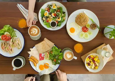 a wooden table topped with plates of breakfast food at Mini House Aonang Hotel SHA Plus in Ao Nang Beach