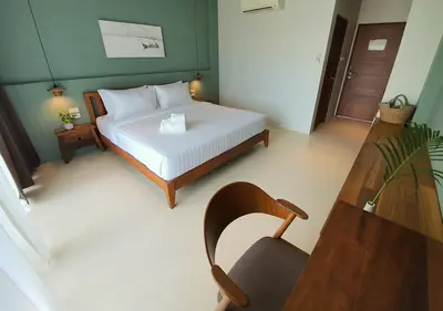 a bedroom with a bed and a table and a chair at Mini House Aonang Hotel SHA Plus in Ao Nang Beach