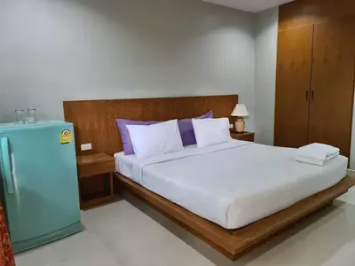 a bedroom with a large bed and a blue refrigerator at ก้านกล้วยแมนชั่น Gankluy Mansion in Phuket Town