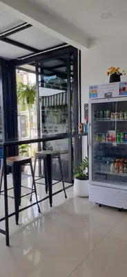 a restaurant with a table and a refrigerator with drinks at ก้านกล้วยแมนชั่น Gankluy Mansion in Phuket Town