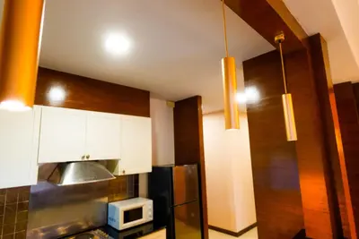 a kitchen with white cabinets and a black refrigerator at Luxurious large size swimming pool villa in Rawai in Ban Saiyuan (1)
