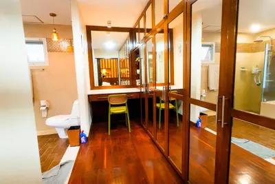 a bathroom with a toilet and a green chair at Luxurious large size swimming pool villa in Rawai in Ban Saiyuan (1)