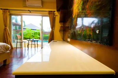 a living room with a table and a painting on the wall at Luxurious large size swimming pool villa in Rawai in Ban Saiyuan (1)