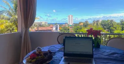 a laptop computer sitting on a table with a plate of fruit at OASIS VILLA Karon Beach in Karon Beach