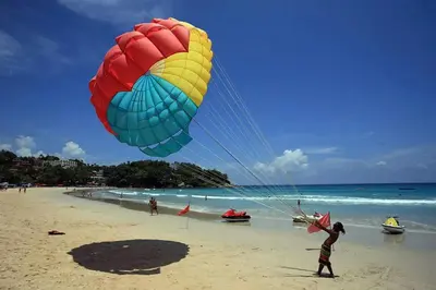 a person flying a large kite on the beach at Kata Beach OZONE Superb Fully Equipped studio kitchen washing machine air con in Kata Beach