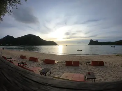 a beach with lounge chairs and the ocean at sunset at Phi Phi Blue Lagoon in Phi Phi Don