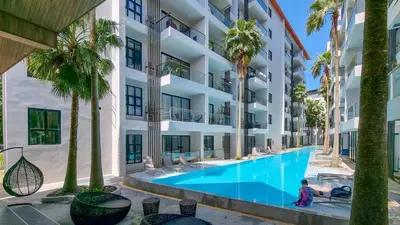 an apartment building with a swimming pool and palm trees at 2bdr Apartment near Surin beach PALM-C302 in Surin Beach