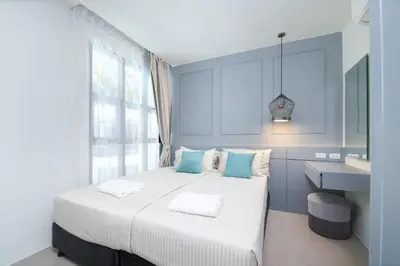a bedroom with a white bed with blue walls and a sink at 2bdr Apartment near Surin beach PALM-C302 in Surin Beach