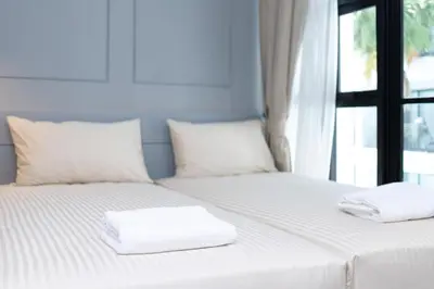 two white towels sitting on a bed with a window at 2bdr Apartment near Surin beach PALM-C302 in Surin Beach