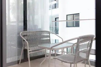 two chairs and a table on a balcony at 2bdr Apartment near Surin beach PALM-C302 in Surin Beach